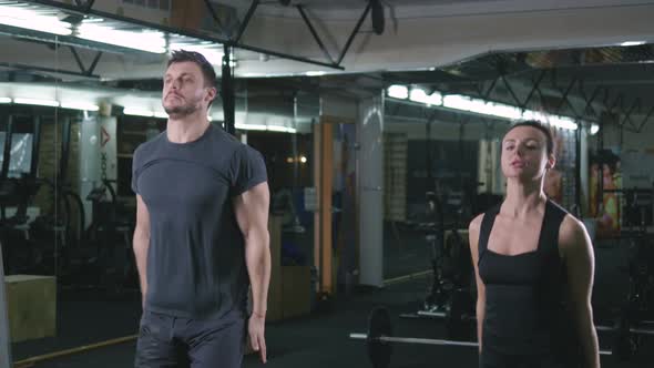 Muscular Fit Couple Doing Sport Exercises in Gym