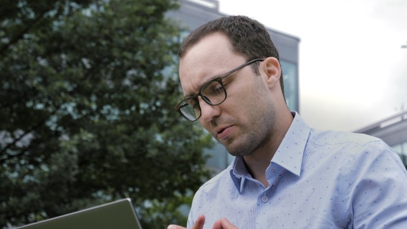 Online Video Chat on Laptop by Businessman Sitting Outdoor