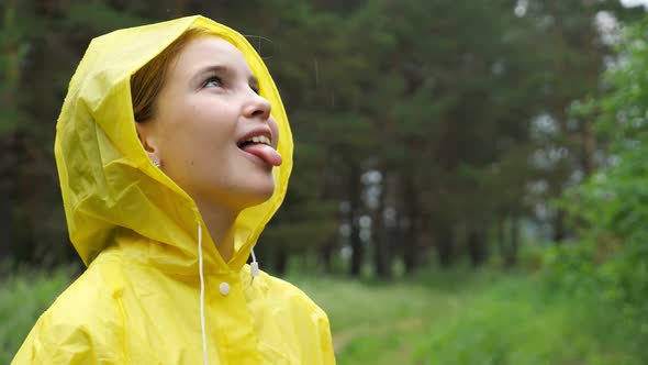 Happy Girl Sticks Out Tongue to Catch Raindrops on Rainy Day