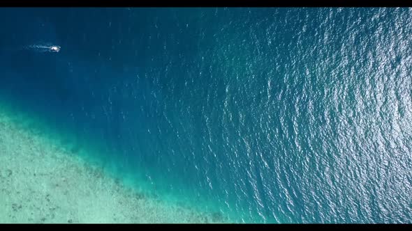 Aerial flying over seascape of tropical island beach wildlife by transparent lagoon with white sandy