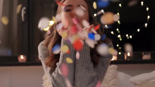 Woman Blowing Confetti From Her Hands at Home