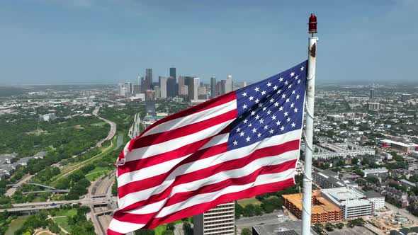 Proud to be an American theme. Houston Texas city skyline. Aerial orbit on windy day. Slow motion.