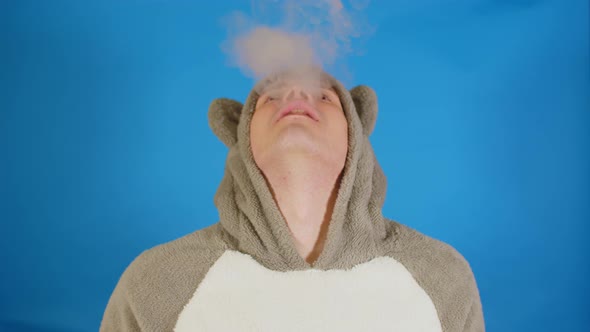 Man in Hoodie with Ears Vapes Tipping His Head Back