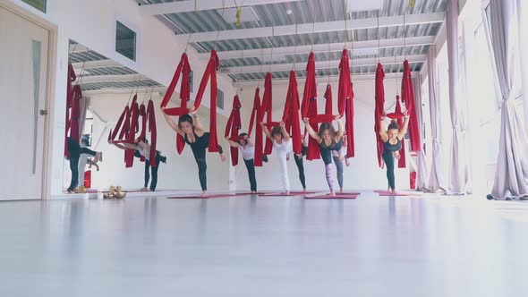 Ladies Group Stands Synchronously in Modern Fly Yoga Asana