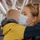 A Young Mother Hugs Her Little Son at the Airport They Have Medical Masks - VideoHive Item for Sale