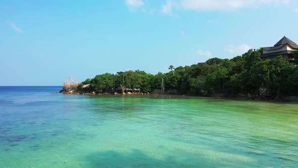 Daytime birds eye clean view of a white paradise beach and turquoise sea background in 4K