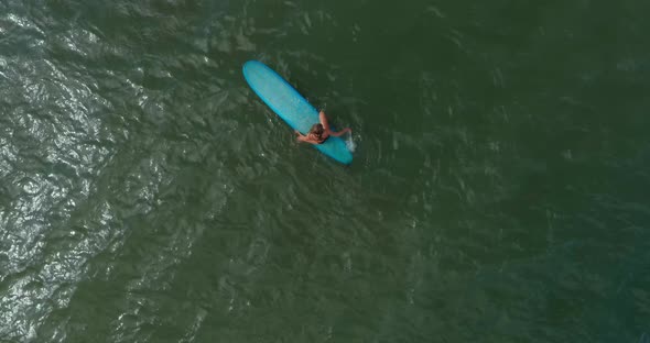 Birds eye view of female surfer in the Gulf of Mexico off the coast of Lake Jackson in Texas