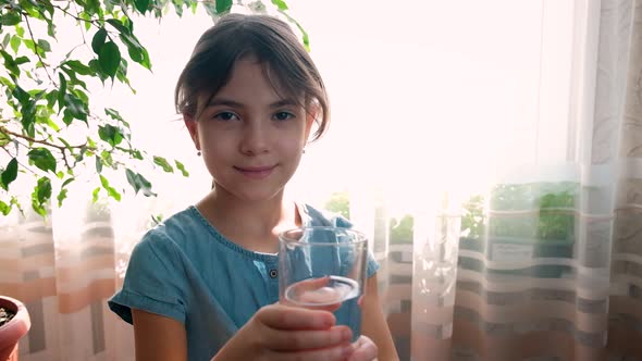 The Child Drinks Water From a Glass