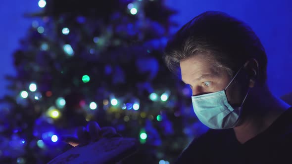 A Man in a Medical Mask Opens a Gift