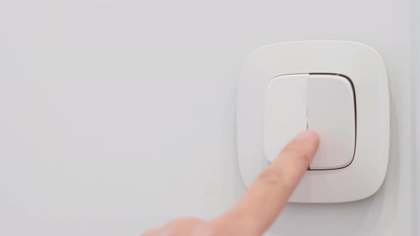 Man Hand Turns on the White Button Light