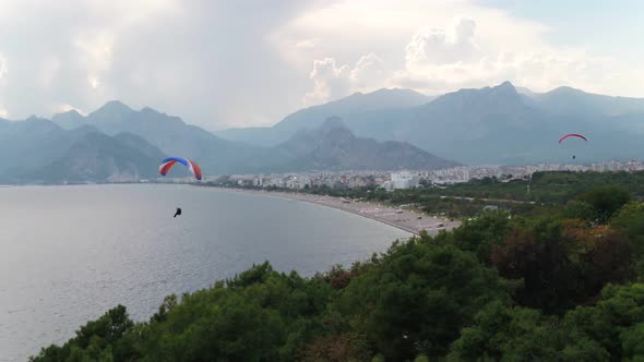 Paragliding Over Sea With View Of Mountains And Green