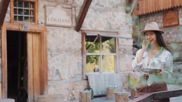 Woman Eating Something Looking at Camera