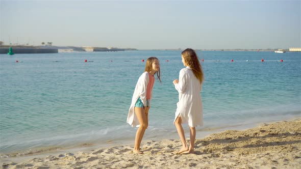 Little Happy Funny Girls Have a Lot of Fun at Tropical Beach Playing Together.