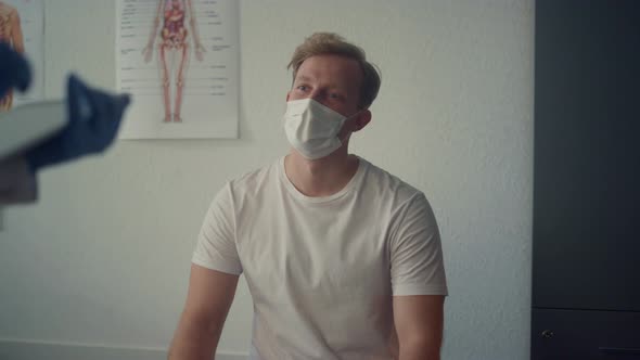 Young Guy Patient Consulting with Medical Specialist Sitting Clinic Close Up