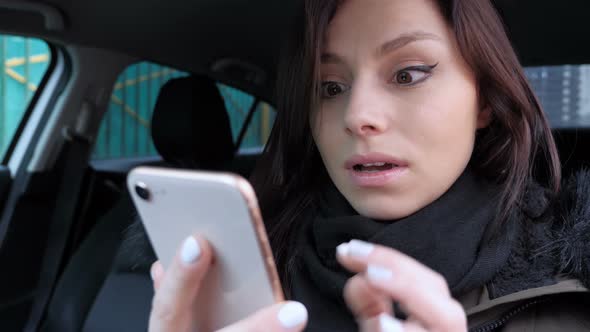 Woman Excited for Success While Using Phone, Sitting  in Car