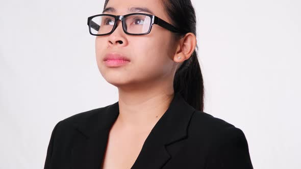 Confident Asian businesswoman looking up on white background in studio