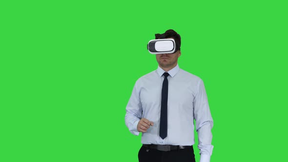 Businessman in VR Glasses and Interacting with Virtual Reality Objects on a Green Screen, Chroma Key