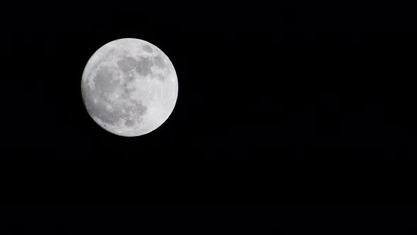 full moon going up on the dark black sky 