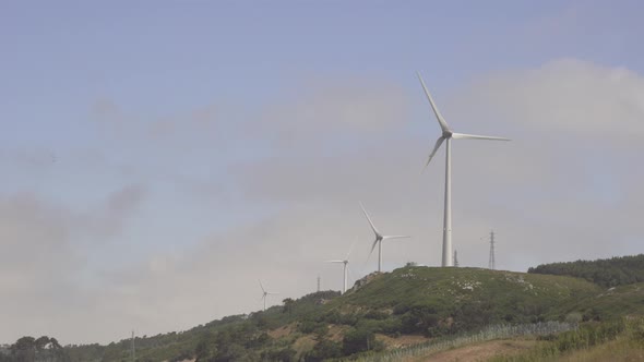 Wind-powered fans blowing in the wind on small hills