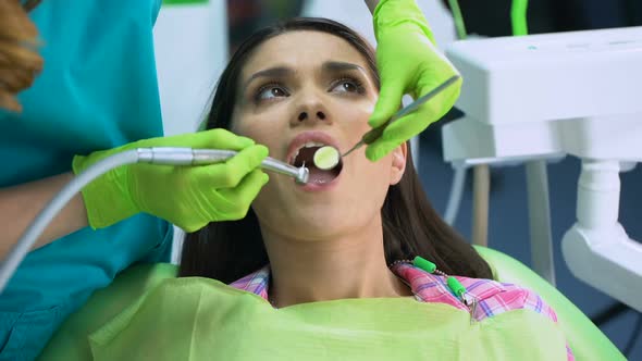 Stomatologist Using Dental Drill to Treat Teeth, Calm Smiling Patient, No Fear