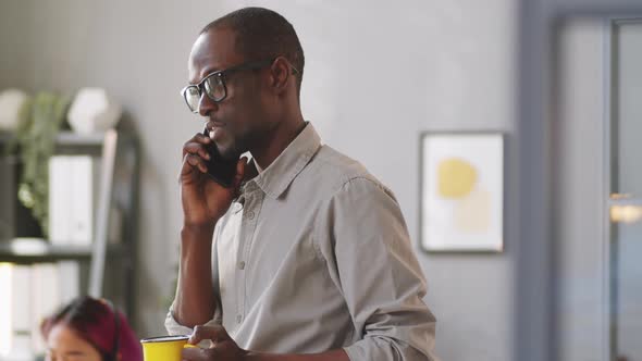 Afro-American Man Speaking on Mobile Phone in Office