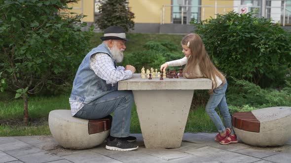 Grandpa and Grandchild Having Fun Playing Chess