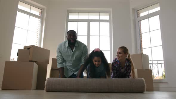 Joyful Family Rolling Carpet on Floor in New House