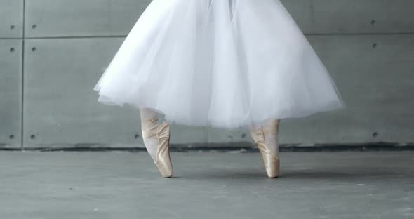 Slow Motion Woman in a White Tutu Dance Ballet and Balancing in Pointe Shoes View of the Legs White