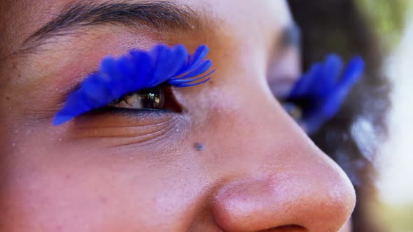 Woman in blue eye lashes at music festival 4k
