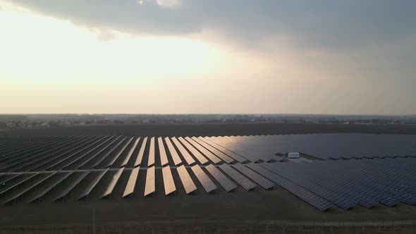 Aerial Drone View Into Large Solar Panels at a Solar Farm at Early Spring Sunset