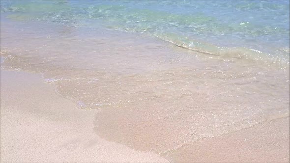 Close up of waves break on tropical yellow sand beach