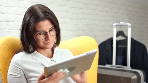 Focused Businesswoman in Trendy Glasses Thinking and Typing Text Using Tablet Pc Medium Closeup