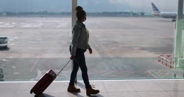 Mature african woman wearing safety face mask inside the international airport