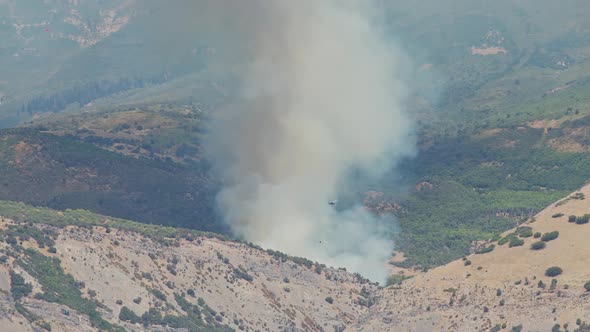 Helicopter flying in front of smoke from wildfire in Utah