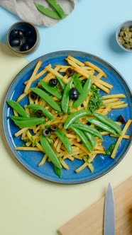 Vertical Tabletop Video Chef Adds Black Olives to the Fried Potato Dish