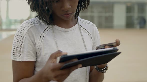 Focused African American Woman Typing Card Number on Tablet