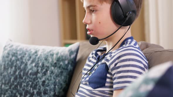 Boy with Gamepad Playing Video Game at Home