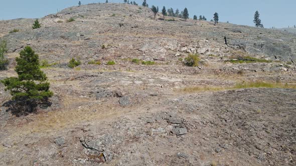 A dry, steep cliff at the shore of Okanagan Lake in Kelowna, BC. Aerial ascending fly over