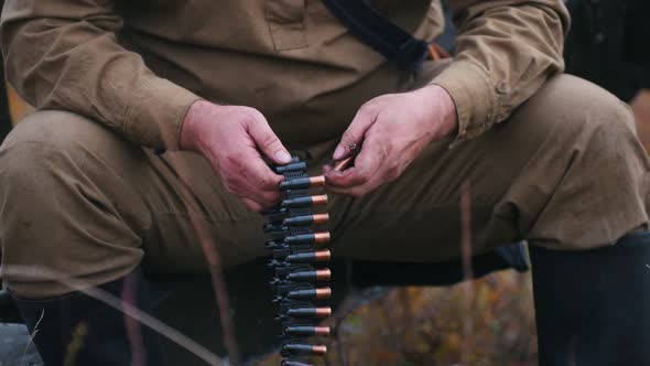 A Man Soldier Prepares the Ammunition for the Charge in the Machine Gun