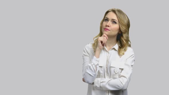 Young Businesslady Looking Up and Thinking Holding Her Chin