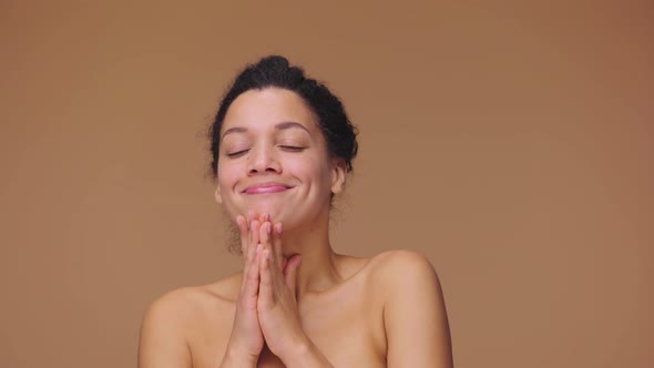 Beauty Portrait of Young African American Woman is Dreaming of Something Pleasant and Smiling