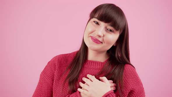 Moved Lovely Caucasian Girl with Dark Brown Hair and Bangs Gasping and Looking Dreamy Over Pink