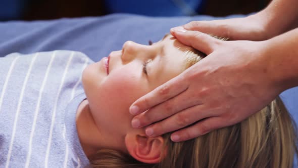 Physiotherapist giving head massage to a boy 4k