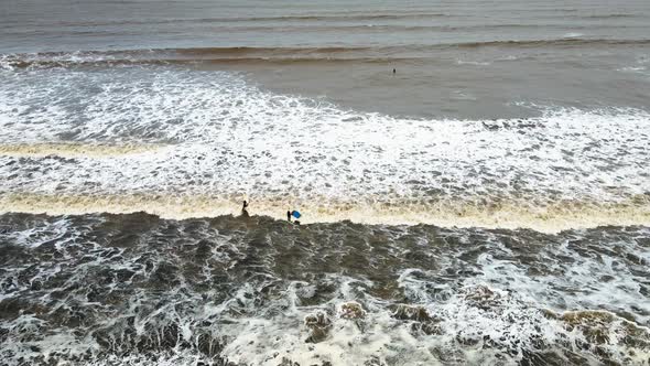 beach at vasi rajodi beach surfing on waves timelaps india mumbai maharashtra water sport drone shot