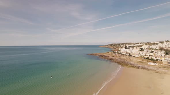 Aerial view of Praia da Luz, Algarve.  Small ocean waves washing on sand beach. Seaside townhouses.