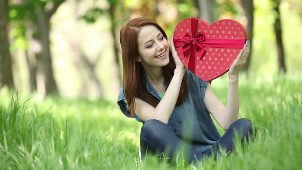 Young girl hold red heart shape gift box