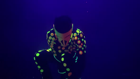 Dancer in Fluorescent Costume and Mask Performs Laser Show