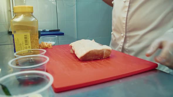 Cook Puts a Piece of Meat on a Cutting Board