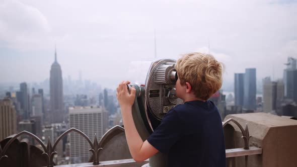 Boy Looking Through Telescope To View New York Skyscrapers