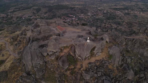 Aerial drone circling above evocative Monsanto hilltop fortress in Portugal